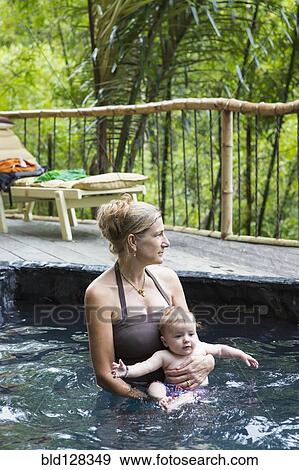 Caucasian mother and baby relaxing in pool View Large Photo Image Stock Photo - Caucasian mother and baby relaxing in pool. Fotosearch