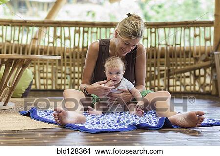 Caucasian mother and baby sitting on floor View Large Photo Image Picture - Caucasian mother and baby sitting on floor. Fotosearch