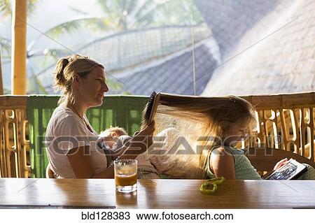 Caucasian mother brushing daughter's hair on patio View Large Photo Image Stock Image - Caucasian mother brushing daughter's hair on patio. Fotosearch