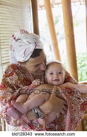 Stock Image - Caucasian mother cradling baby. Fotosearch