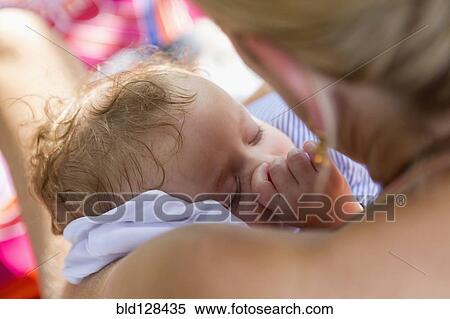Stock Photography - Caucasian mother cradling baby. Fotosearch