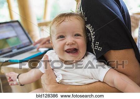 Stock Photograph - Caucasian mother holding baby boy. Fotosearch