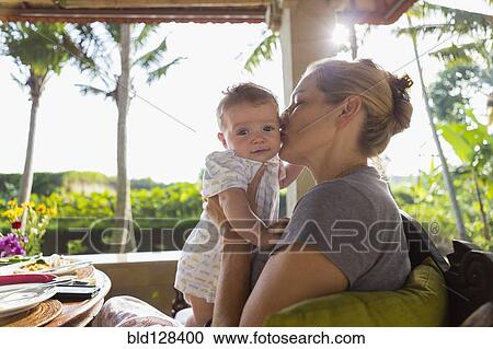 Caucasian mother kissing baby boy's cheek View Large Photo Image Stock Image - Caucasian mother kissing baby boy's cheek. Fotosearch