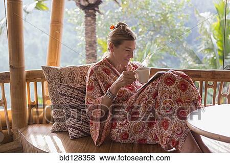 Caucasian woman drinking coffee on patio View Large Photo Image Stock Photo - Caucasian woman drinking coffee on patio. Fotosearch