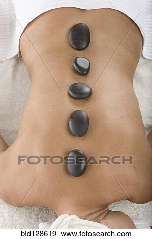 Stock Photo - Caucasian woman having hot stone massage. Fotosearch