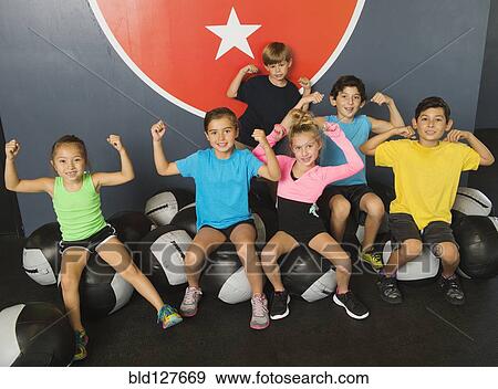 Stock Photo - Children flexing their muscles in gym. Fotosearch