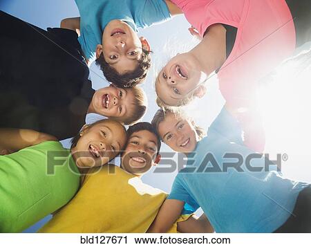 Stock Image - Children smiling in circle outdoors. Fotosearch