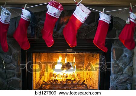 Christmas stockings hanging over fireplace View Large Photo Image Stock Photo - Christmas stockings hanging over fireplace. Fotosearch