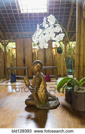 Stock Image - Flowers and statue in Hindu temple, Ubud, Bali, Indonesia. Fotosearch