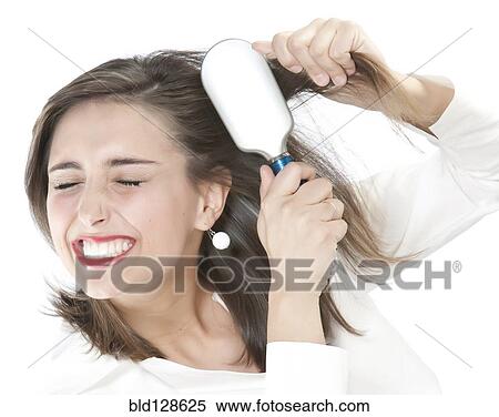 Grimacing woman brushing tangles from hair View Large Photo Image Stock Photography - Grimacing woman brushing tangles from hair. Fotosearch