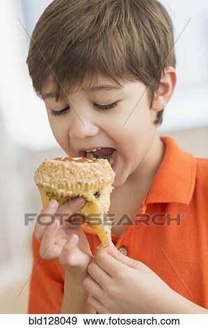 Stock Photo - Hispanic boy eating muffin. Fotosearch