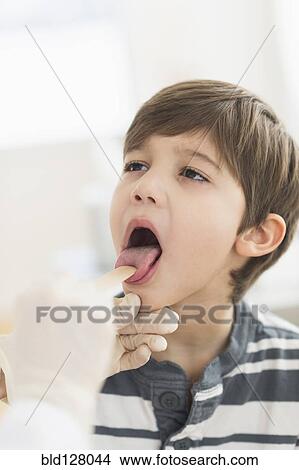 Picture - Hispanic boy getting a checkup at doctor's office. Fotosearch