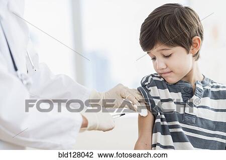 Hispanic boy getting a shot at doctor's office View Large Photo Image Stock Image - Hispanic boy getting a shot at doctor's office. Fotosearch