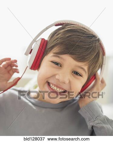 Stock Photo - Hispanic boy listening to headphones. Fotosearch