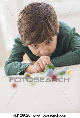 Hispanic boy playing with marbles on floor View Large Photo Image Stock Image - Hispanic boy playing with marbles on floor. Fotosearch