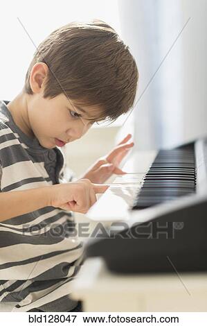 Stock Photo - Hispanic boy practicing piano. Fotosearch
