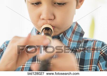 Stock Photo - Hispanic boy practicing recorder. Fotosearch
