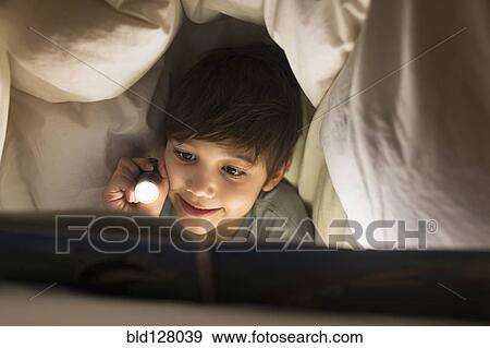 Hispanic boy reading under covers View Large Photo Image Stock Photo - Hispanic boy reading under covers. Fotosearch