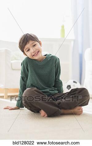Stock Image - Hispanic boy smiling in living room. Fotosearch