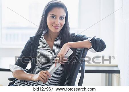 Stock Photo - Hispanic businesswoman smiling in office. Fotosearch