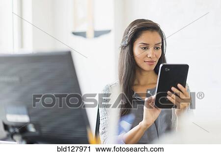Hispanic businesswoman using digital tablet in office View Large Photo Image Stock Image - Hispanic businesswoman using digital tablet in office. Fotosearch