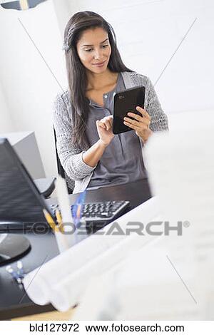 Hispanic businesswoman using digital tablet in office View Large Photo Image Stock Image - Hispanic businesswoman using digital tablet in office. Fotosearch