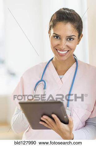 Hispanic nurse using digital tablet in hospital View Large Photo Image Stock Image - Hispanic nurse using digital tablet in hospital. Fotosearch