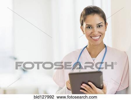 Hispanic nurse using digital tablet in hospital View Large Photo Image Stock Image - Hispanic nurse using digital tablet in hospital. Fotosearch
