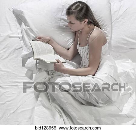 Hispanic woman reading in bed View Large Photo Image Stock Photograph - Hispanic woman reading in bed. Fotosearch