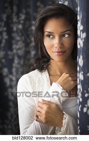 Stock Image - Hispanic woman smiling indoors. Fotosearch
