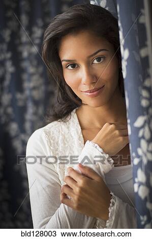 Stock Image - Hispanic woman smiling indoors. Fotosearch