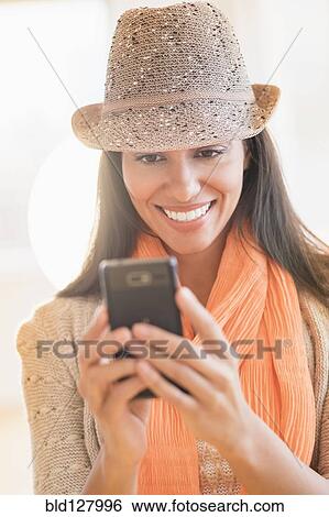 Stock Photograph - Hispanic woman using cell phone. Fotosearch