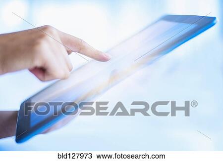 Stock Image - Hispanic woman using digital tablet. Fotosearch