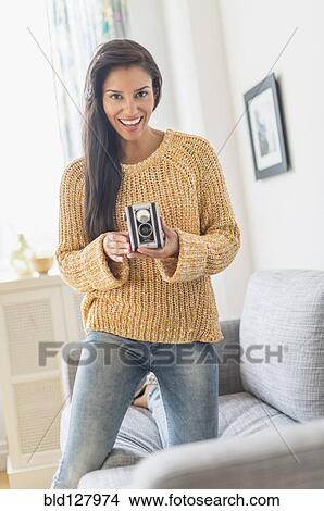 Picture - Hispanic woman using vintage camera. Fotosearch