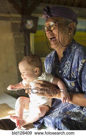 Stock Photo - Hotel concierge holding baby. Fotosearch