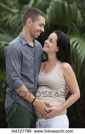 Man holding pregnant wife's belly outdoors View Large Photo Image Stock Photograph - Man holding pregnant wife's belly outdoors. Fotosearch