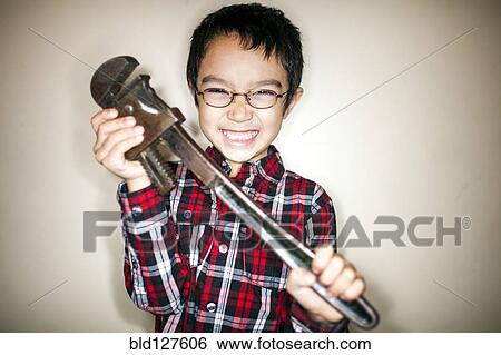 Mixed race boy playing with metal wrench View Large Photo Image Stock Photograph - Mixed race boy playing with metal wrench. Fotosearch