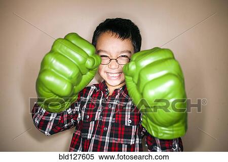 Stock Photography - Mixed race boy playing with toy boxing gloves. Fotosearch
