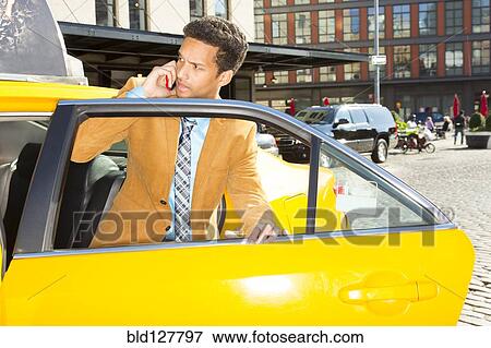 Mixed race businessman climbing out of taxi View Large Photo Image Stock Photo - Mixed race businessman climbing out of taxi. Fotosearch