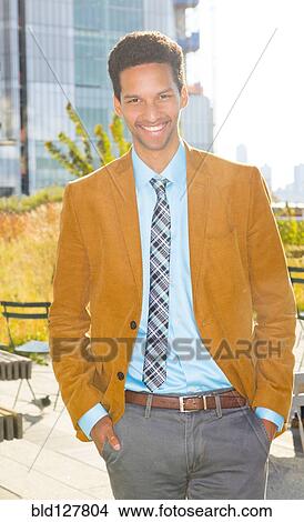 Picture - Mixed race businessman smiling outdoors. Fotosearch