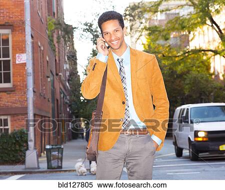 Mixed race businessman talking on cell phone outdoors View Large Photo Image Stock Photography - Mixed race businessman talking on cell phone outdoors. Fotosearch