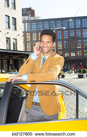Stock Image - Mixed race businessman using cell phone in taxi. Fotosearch