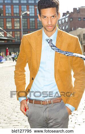Mixed race businessman walking on city street View Large Photo Image Stock Photography - Mixed race businessman walking on city street. Fotosearch