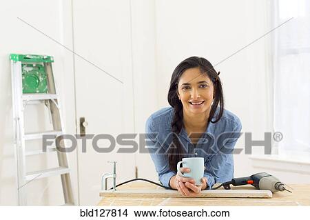 Mixed race contractor having cup of coffee in shop View Large Photo Image Picture - Mixed race contractor having cup of coffee in shop. Fotosearch