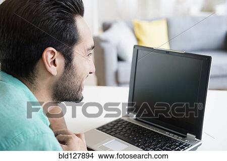 Picture - Mixed race man using laptop. Fotosearch