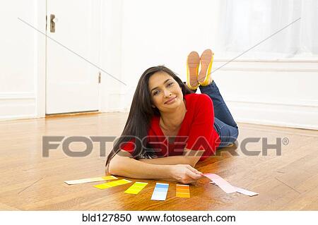 Stock Image - Mixed race woman examining paint swatches. Fotosearch