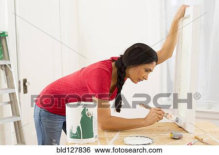 Mixed race woman painting window pane View Large Photo Image Stock Photograph - Mixed race woman painting window pane. Fotosearch