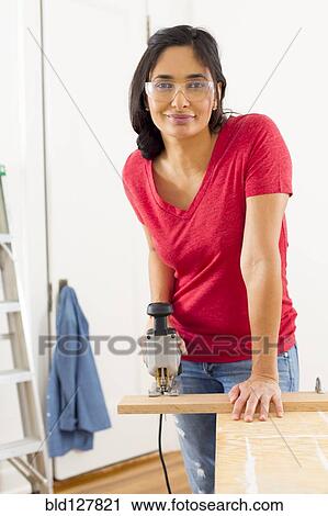 Mixed race woman using jigsaw View Large Photo Image Stock Image - Mixed race woman using jigsaw. Fotosearch