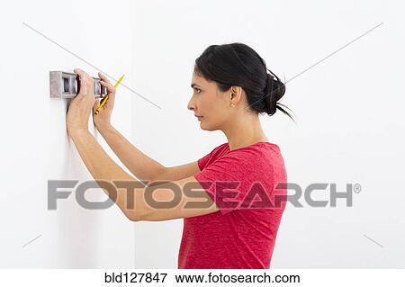 Mixed race woman using level View Large Photo Image Stock Photo - Mixed race woman using level. Fotosearch