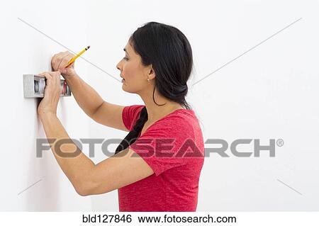 Mixed race woman using level View Large Photo Image Stock Photograph - Mixed race woman using level. Fotosearch